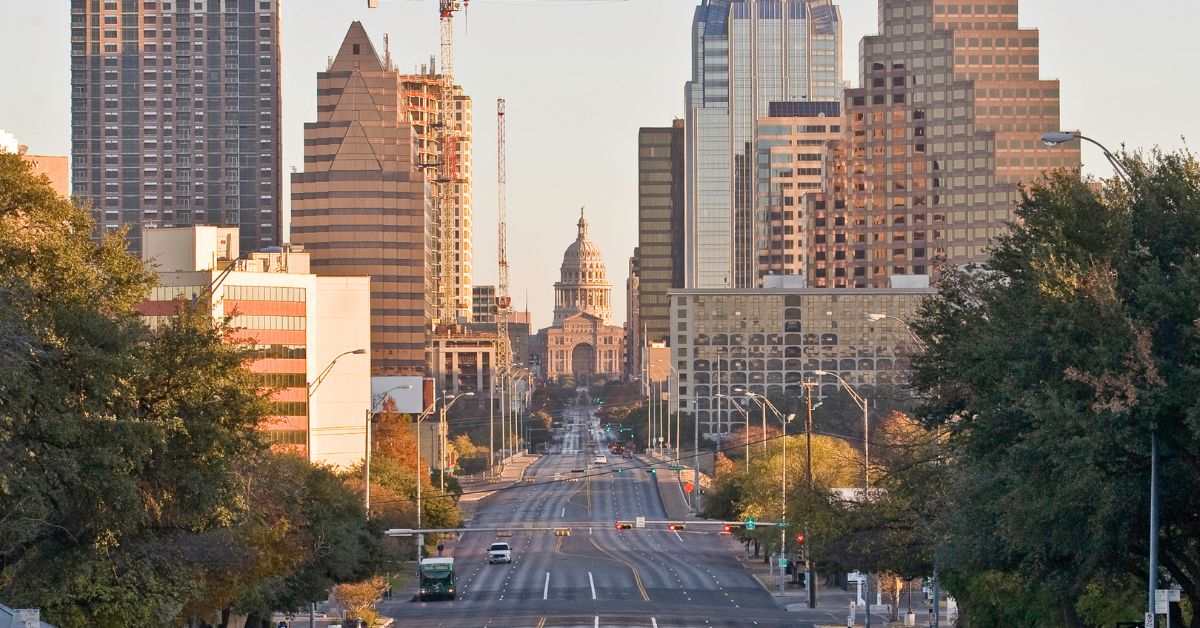 A bustling downtown street in Austin, Texas with towering buildings.