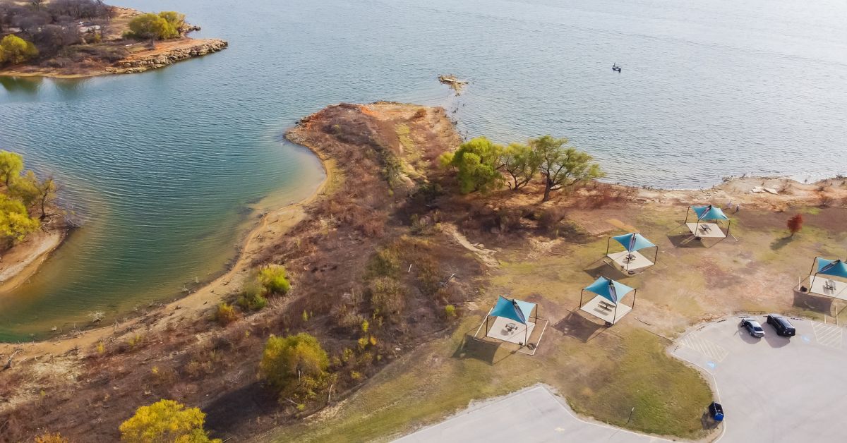 A picturesque lake with a boat dock in one of the best suburbs to retire in Dallas TX, seen from above.