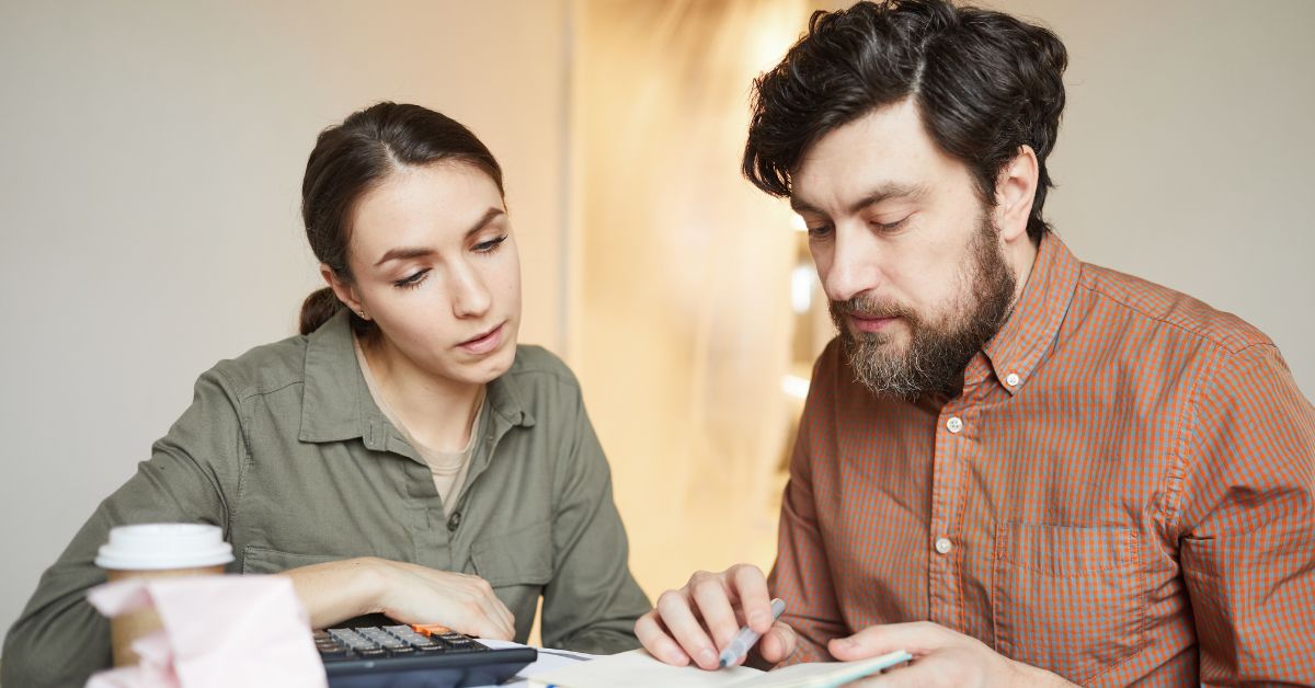 A couple at a table calculating construction costs for a home in Houston.	