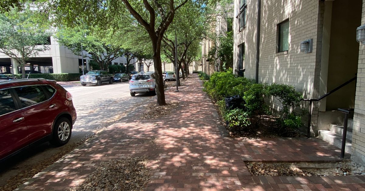 A brick sidewalk with parked cars in the retiring suburbs of Dallas, TX.