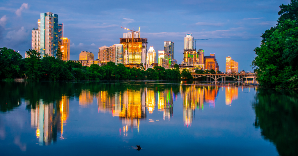 A city skyline is reflected in a body of water, highlighting the beauty of retiring in Austin, TX.