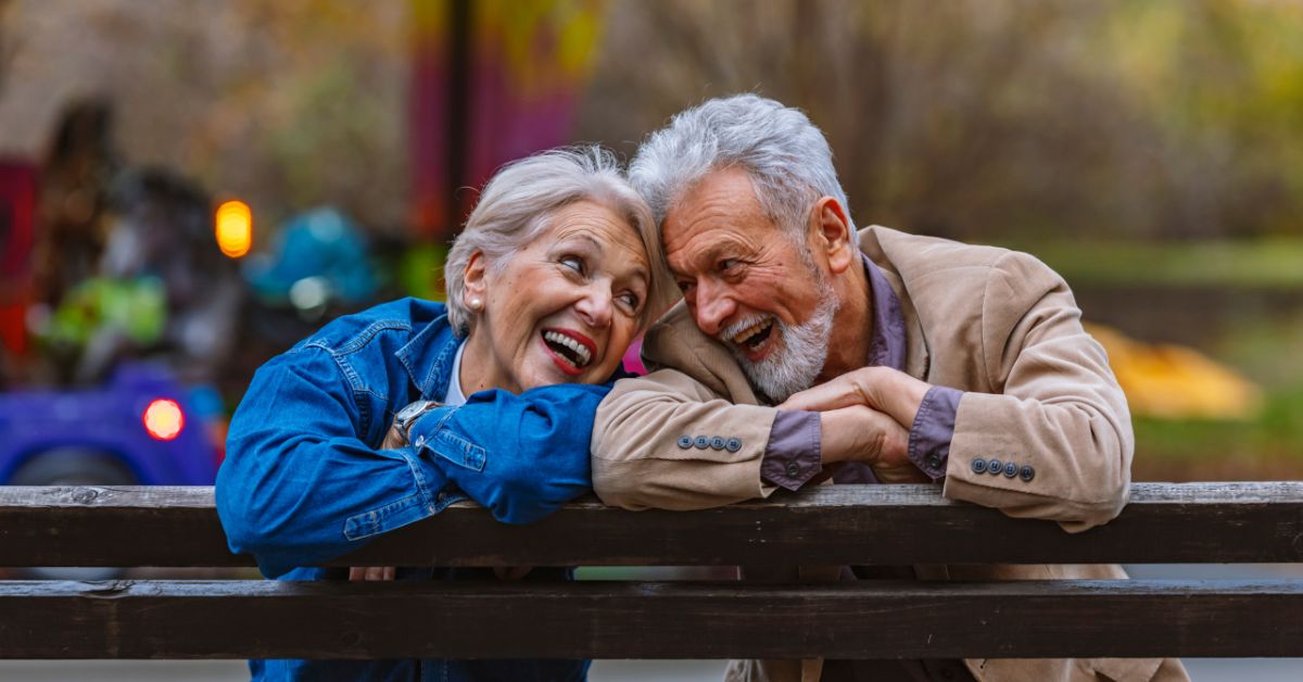 An elderly couple enjoying retirement on a bench in a park in Austin, TX.