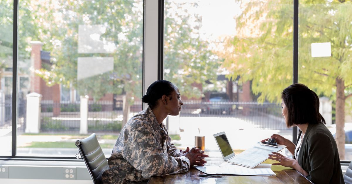 A veteran woman, with a look of determination and curiosity, attentively listens as a lender explains the intricacies of COE (Certificate of Eligibility). Her experience in the military has honed her ability to grasp complex concepts, and now she's focused on comprehending this crucial document that will pave the way for her to access the benefits she's earned through her service.